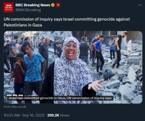 A person in a white and black head scarf standing in front of a destroyed building
Description automatically generated